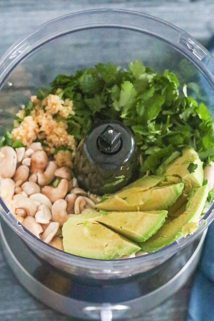 Ingredients for avocado sauce in a food processor waiting to be mixed