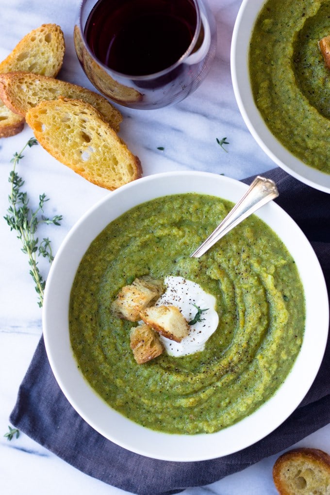 A white bowl of broccoli soup sitting on a table