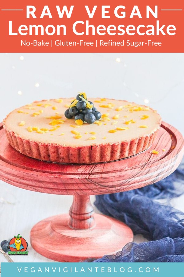 A cheesecake topped with lemon rind and blueberries on a cake stand
