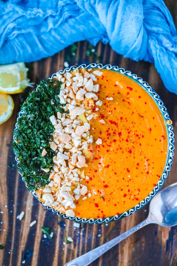 A blue bowl filled with soup with chickpeas in it Chickpea