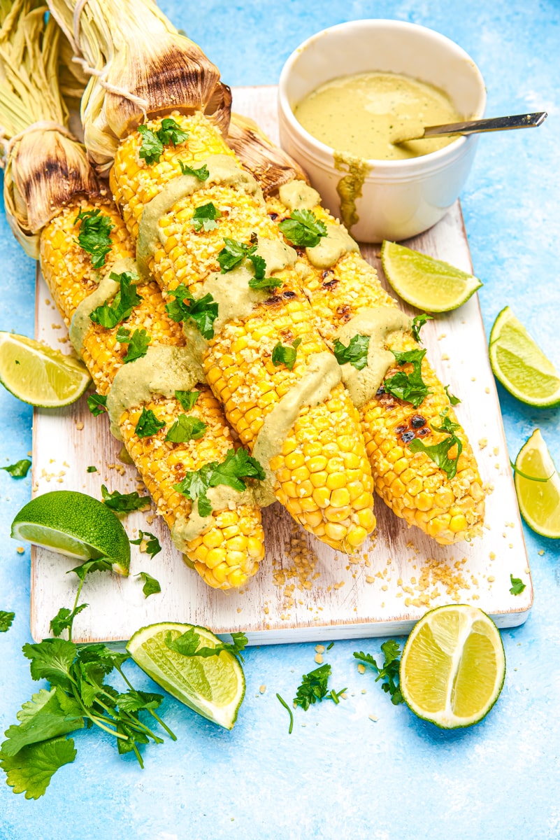 overhead view of Vegan Mexican Street Corn garnished with cilantro and limes.