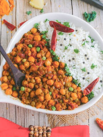chickpea coconut curry in a white bowl on a wooden table