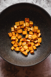 overhead view of browned tofu in a wok
